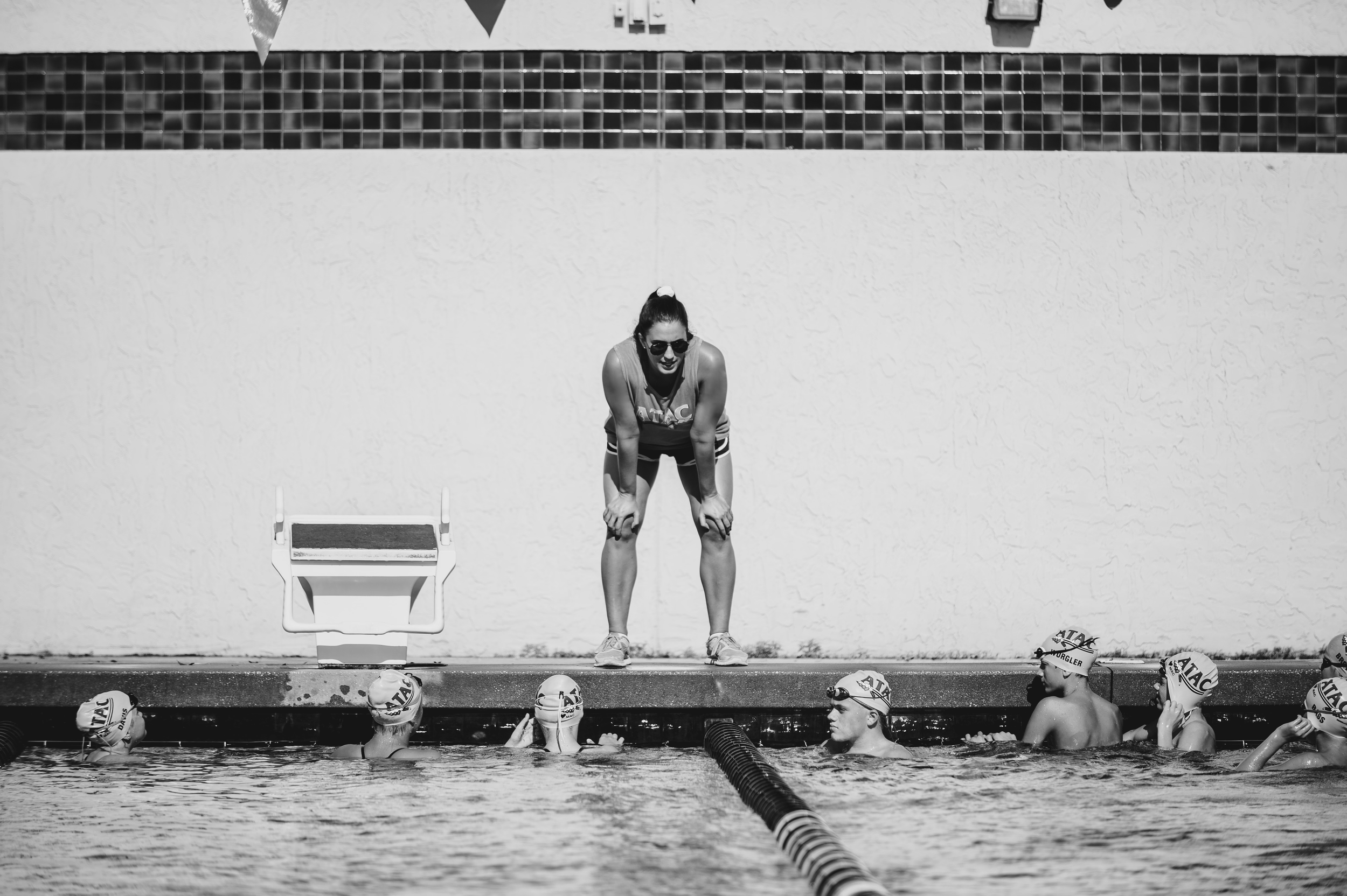 Dr. Savannah Landis speaking with a swim team from the pool deck