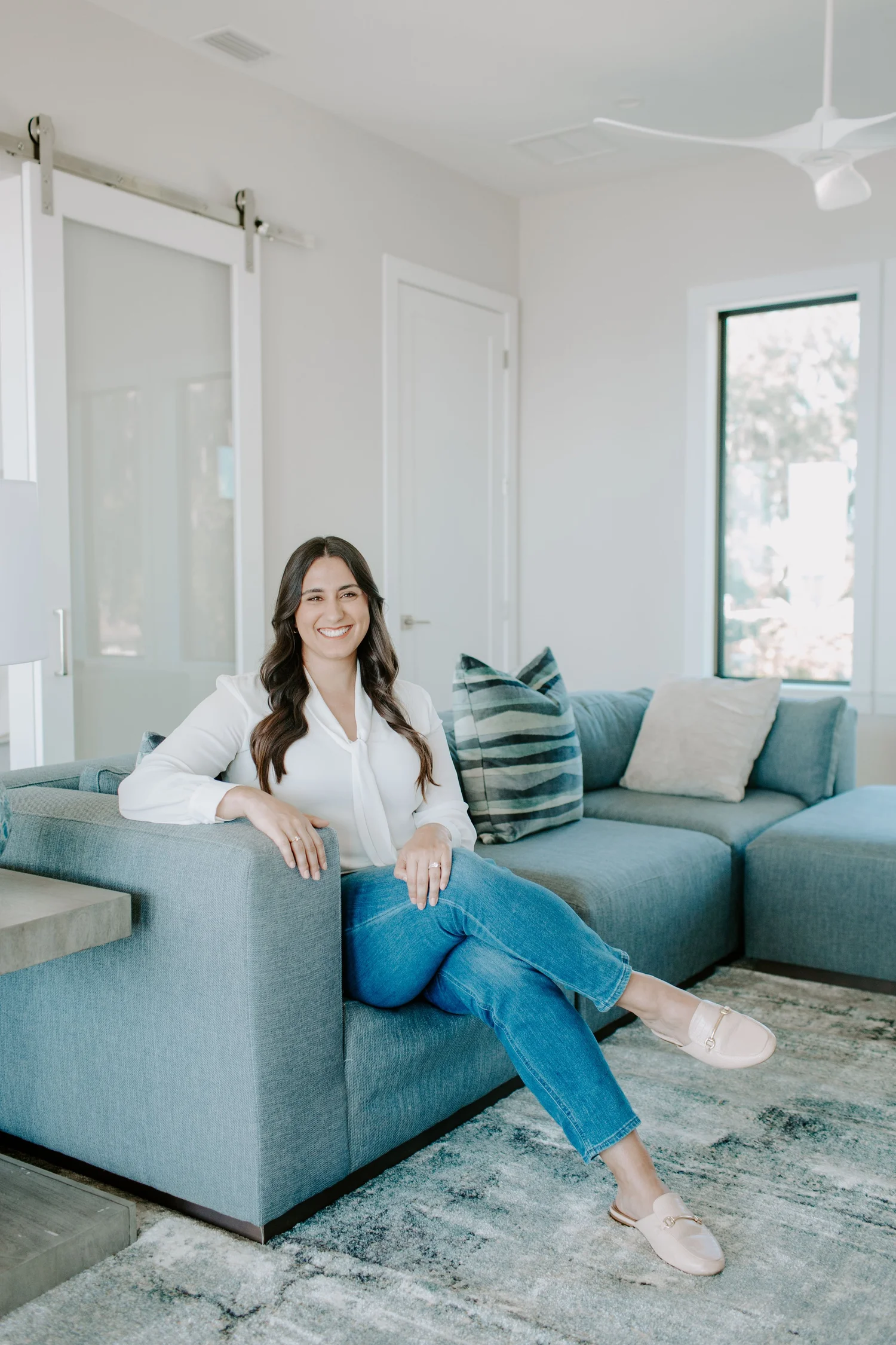 Dr. Savannah Landis, Psy.D., sitting on the sofa in her Jacksonville office