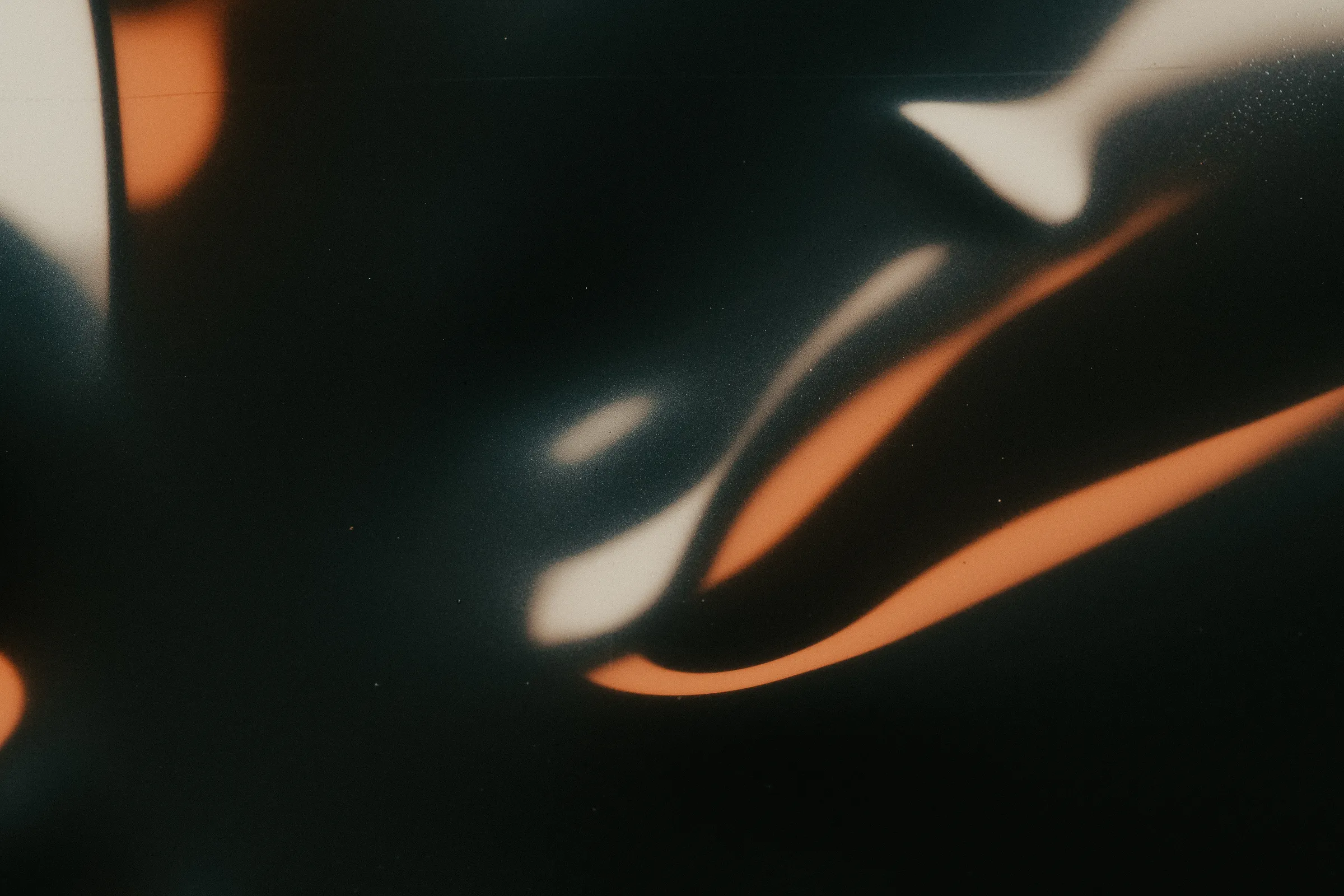 Soft abstract shapes in copper and cream on a dark background