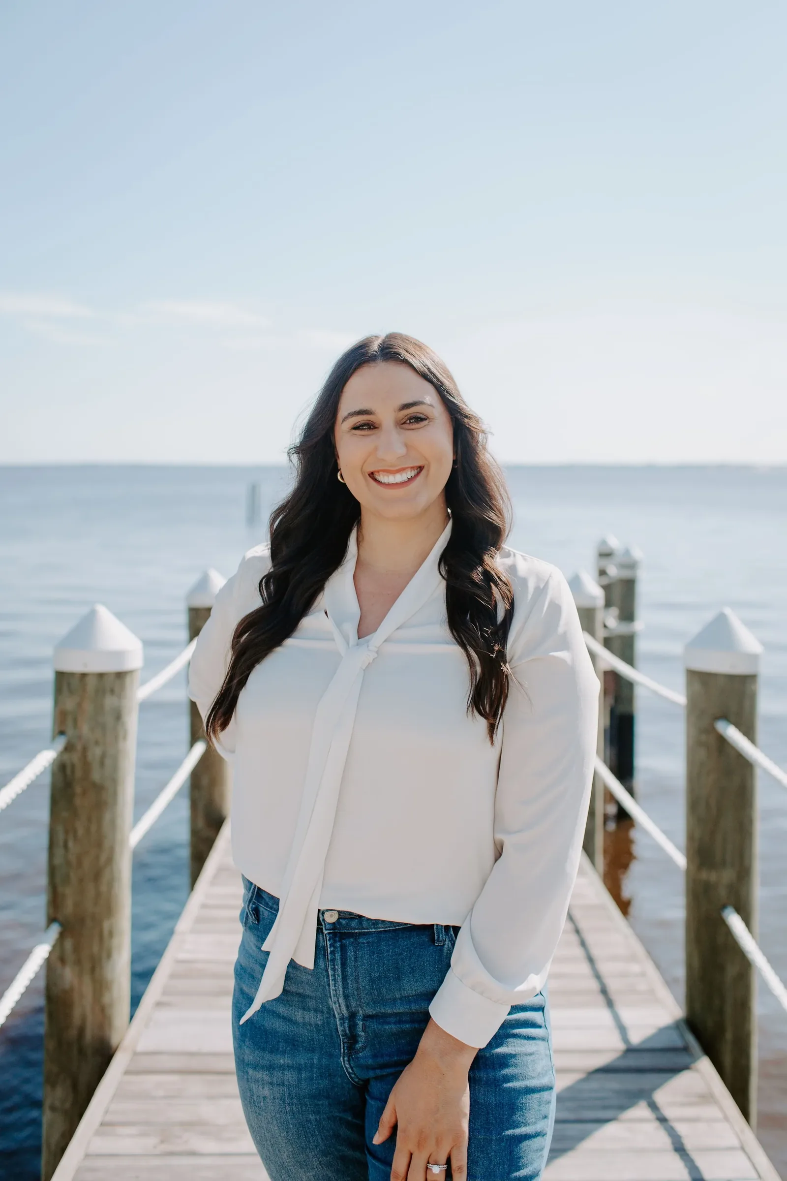 Dr. Savannah Landis, Psy.D., standing on a wooden dock over the water