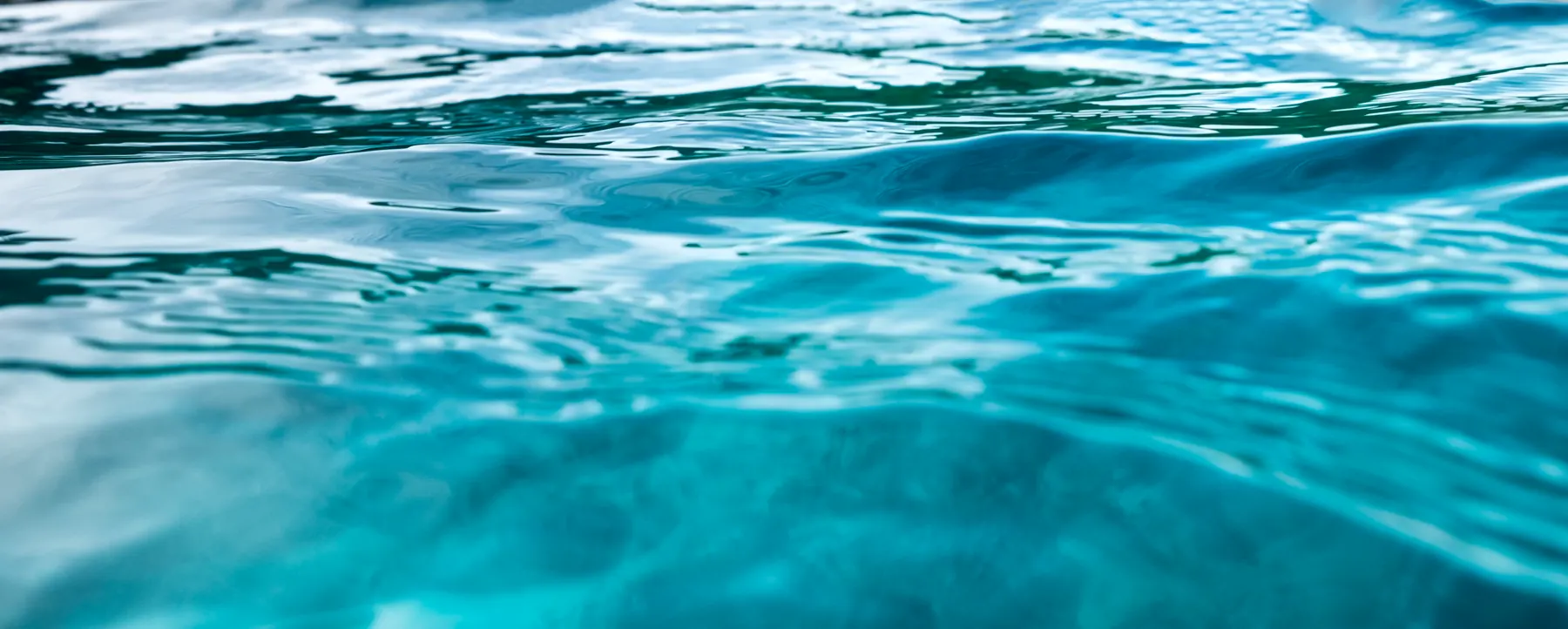 The surface of the ocean seen at eye level, light moving across the water