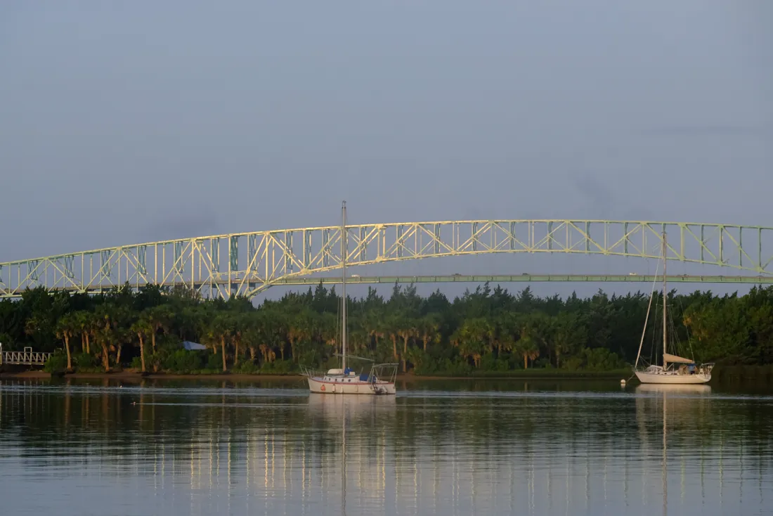 Sailboats moored on the St Johns River beneath a steel bridge