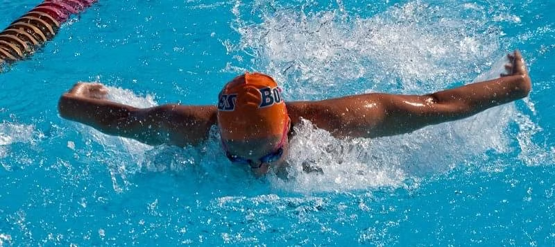 A swimmer mid stroke in the butterfly