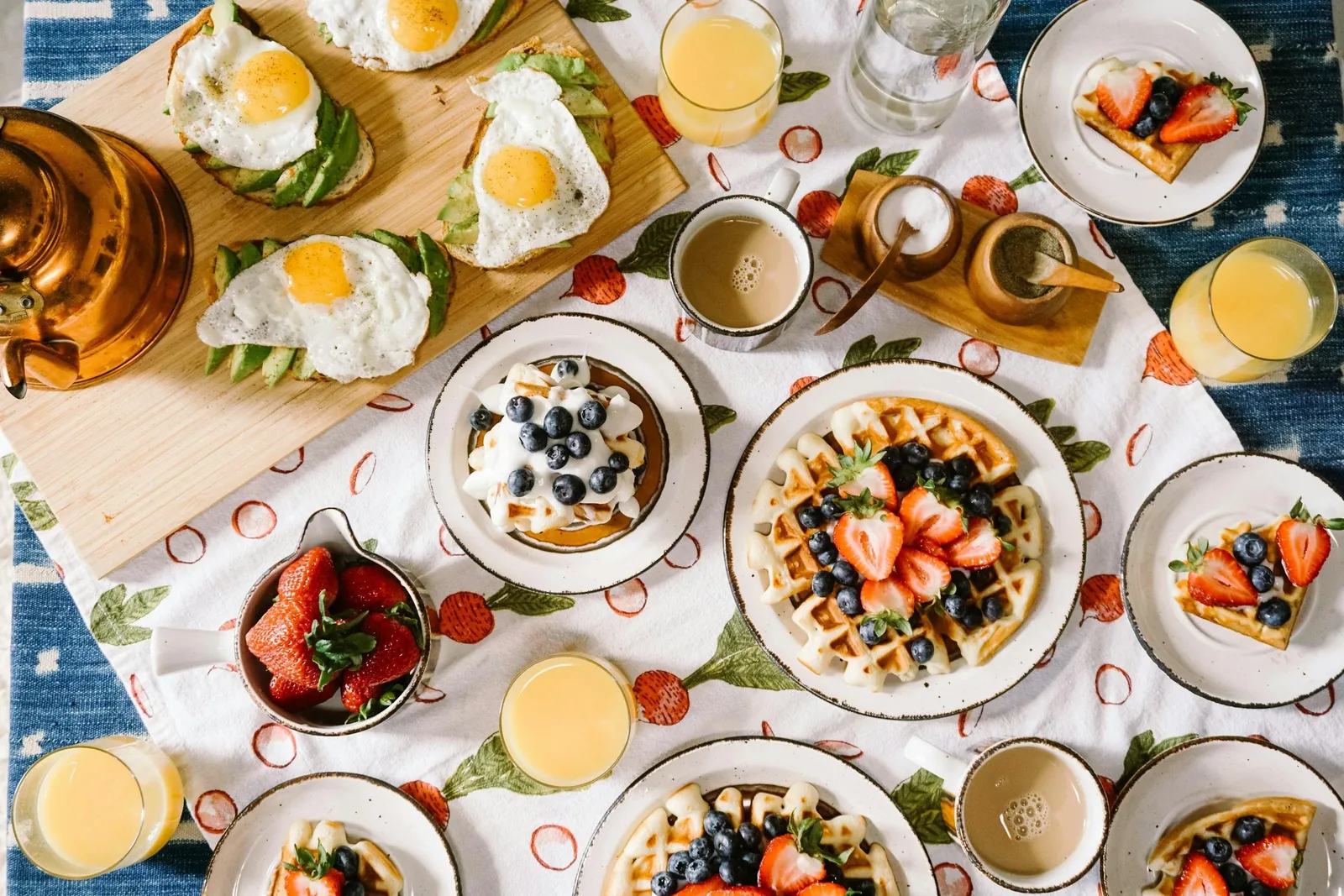 A shared table set with a varied, colourful spread of food, eaten without rules